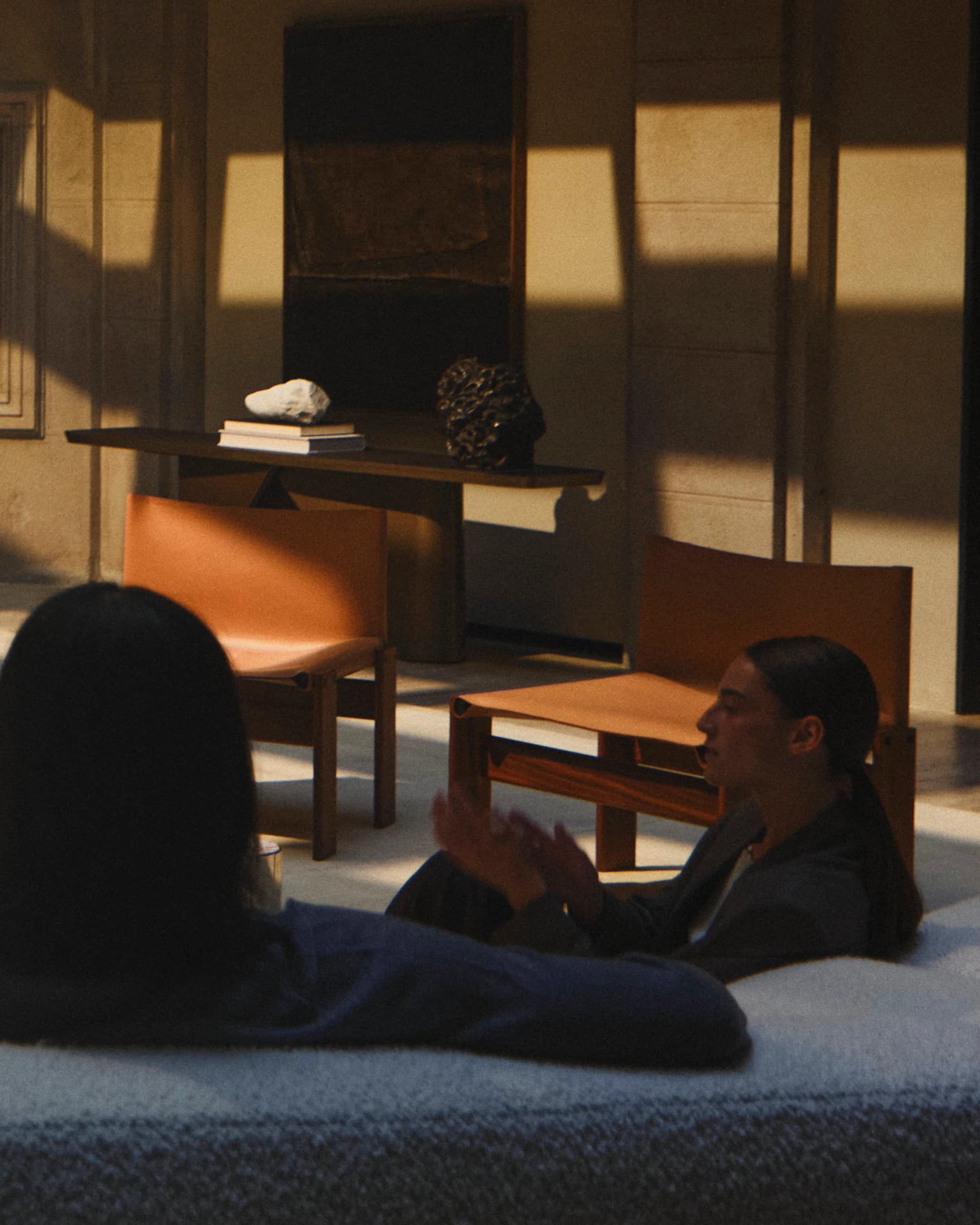 Two people in a sunlit room, the conversation about to turn