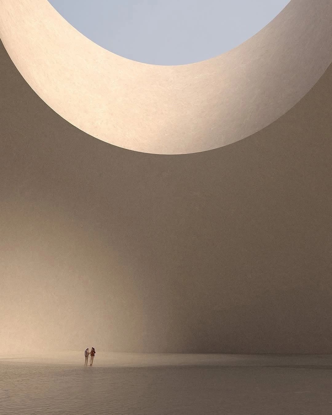 A vast, warm room under a circular opening, two small figures standing together in the light